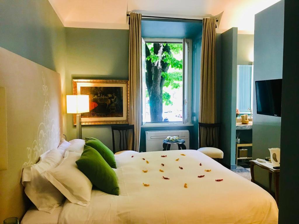 a bedroom with a bed with green pillows and a window at Santa Monica Townhouse in Rome