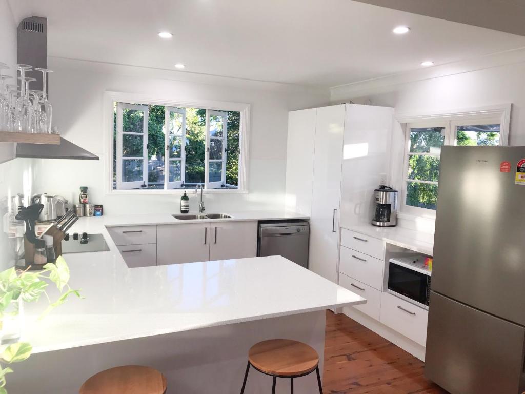 a kitchen with white cabinets and a white counter top at 4 bedroom house - Walk to Southbank in Brisbane