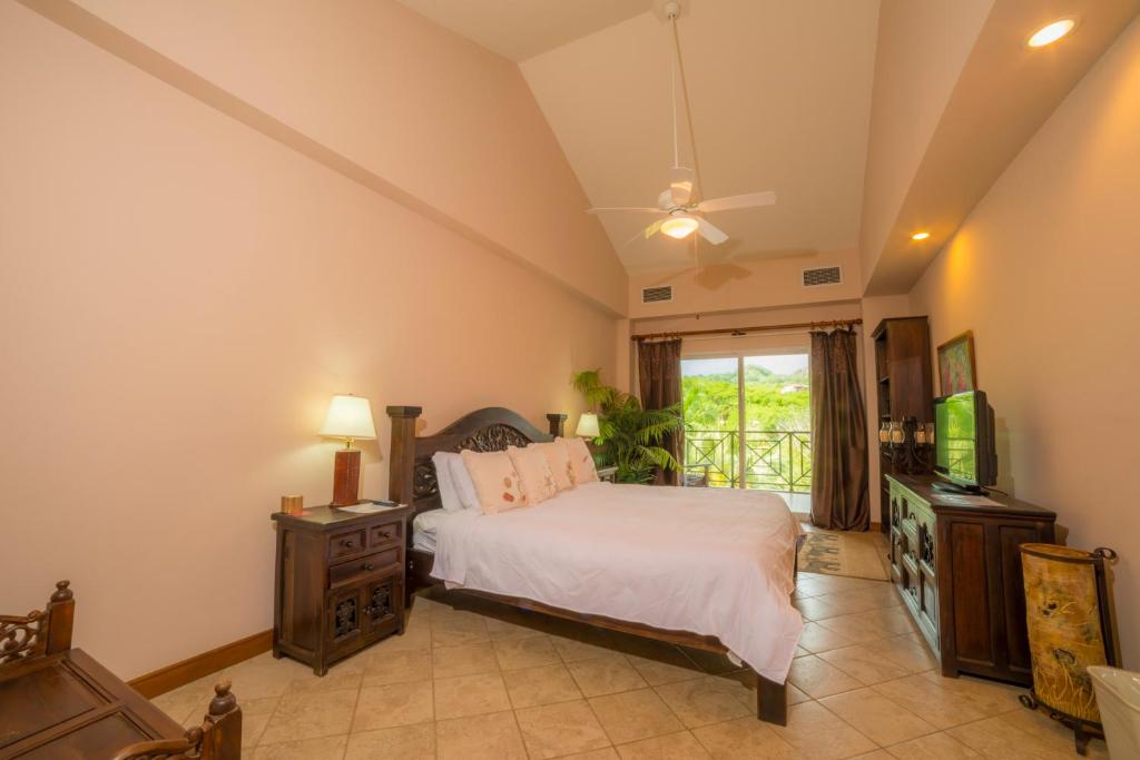a bedroom with a bed and a television at Los Suenos Resort Veranda 4B by Stay in CR in Herradura