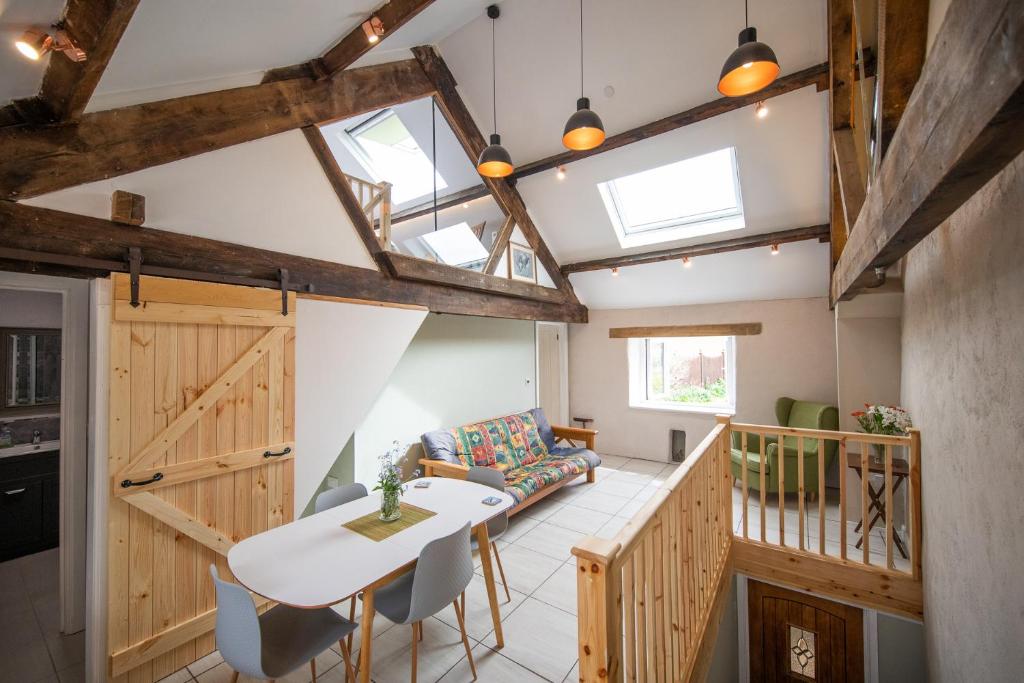 a kitchen and living room with a table and chairs at Black Mountains Barn in Abergavenny