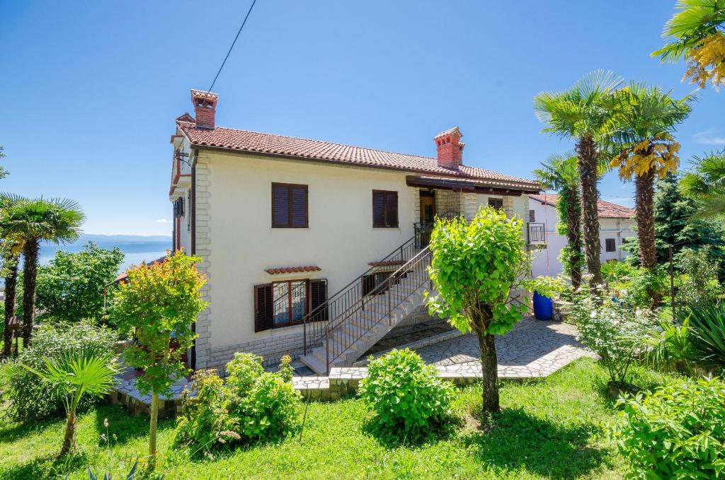 een exterieur van een huis met palmbomen bij Apartments Zeljko in Lovran