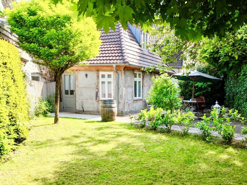 een huis met een tuin met een tafel en een paraplu bij Altstadt Apartments Verden in Verden