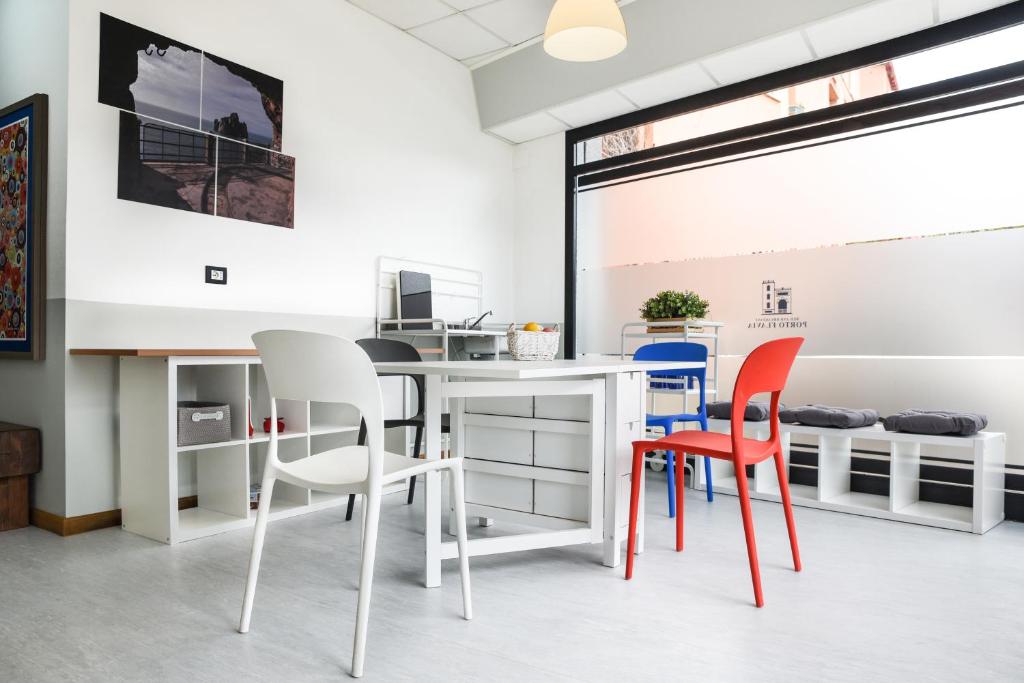 un ufficio con scrivania e sedie bianche di Bed and Breakfast Porto Flavia a Iglesias