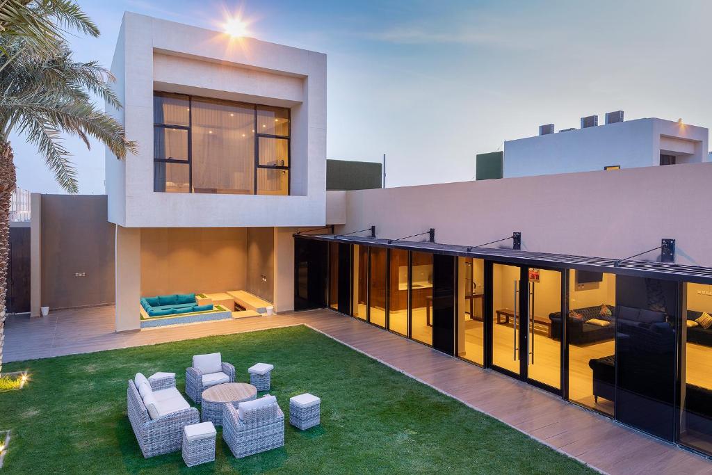 an exterior view of a house with chairs and a lawn at The One Hotel Resorts - Riyadh in Riyadh