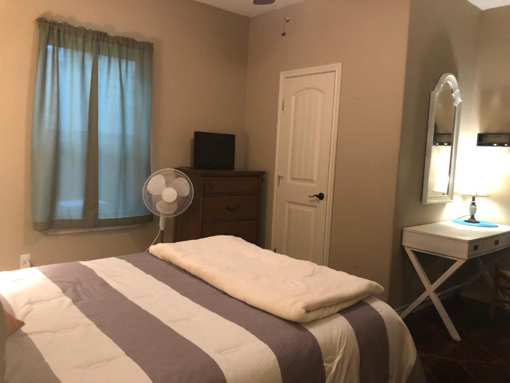 1 dormitorio con cama, escritorio y espejo en Little House on the Corner, en Livingston