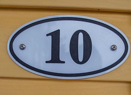 a sign on a wooden wall with the number at The Pines Motel and Cottages in Rustico