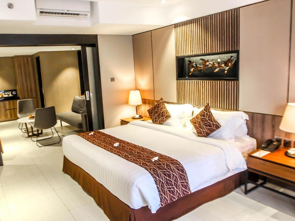 A bed or beds in a room at The Nest Hotel Nusa Dua