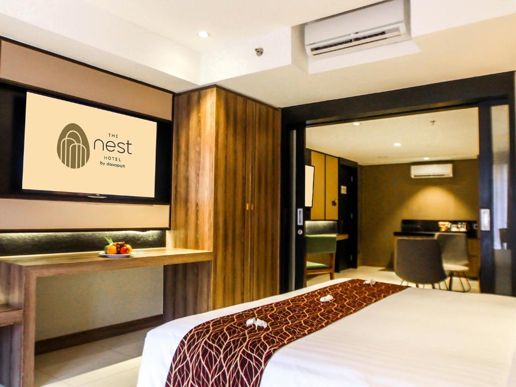 A bed or beds in a room at The Nest Hotel Nusa Dua