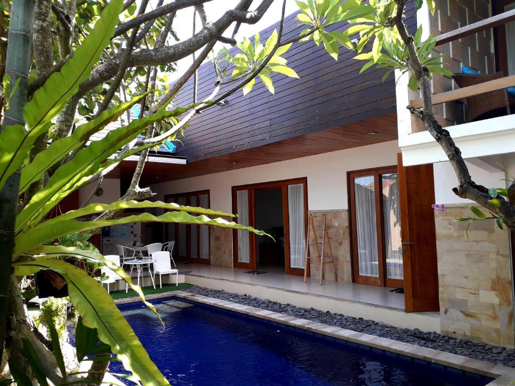 a house with a swimming pool in front of it at Agus Villa in Sanur