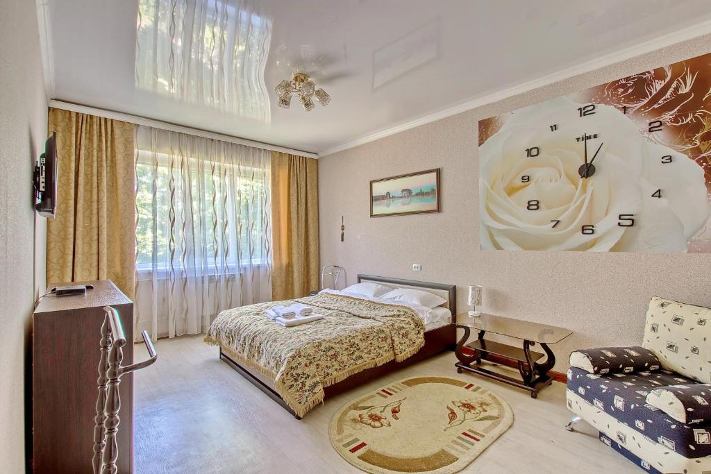 a bedroom with a bed and a clock on the wall at Cozy apartment on Rozybakiev 145. Atakent in Almaty