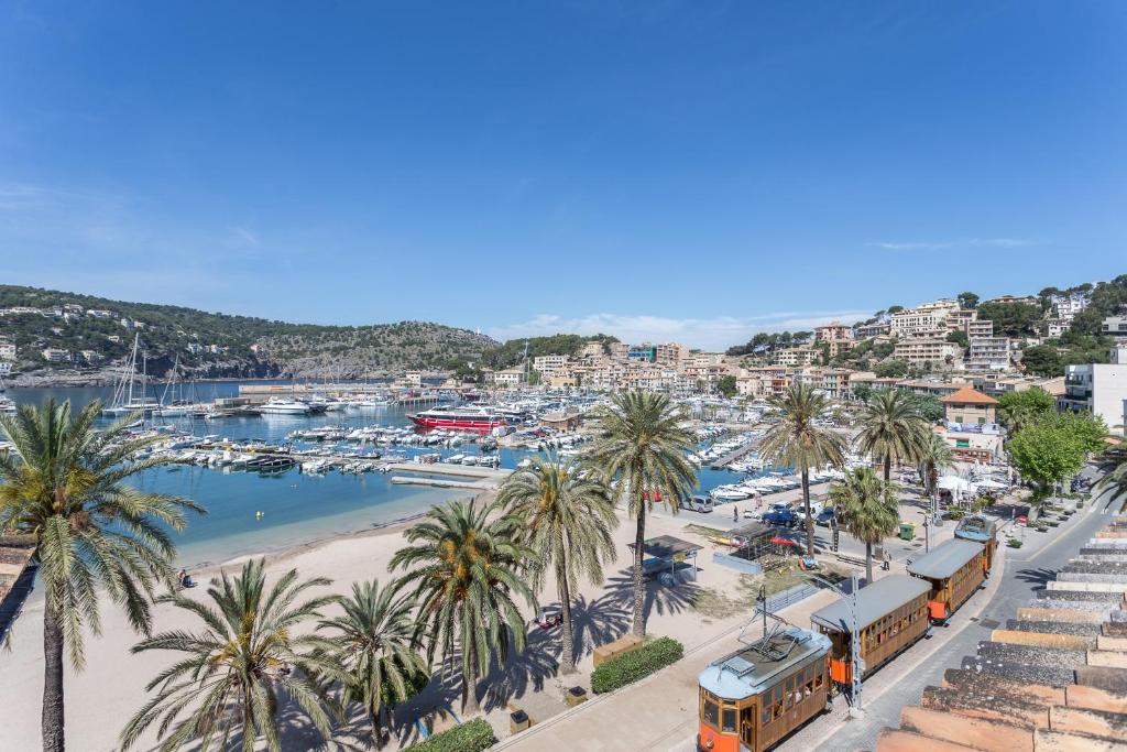 a view of a beach with palm trees and a train at FERGUS Style Soller Beach in Port de Soller