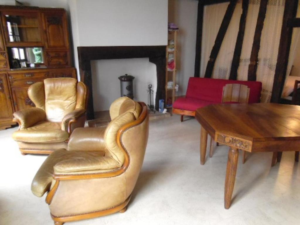 a living room with two chairs and a table at Le trou dans le mur in Uzerche