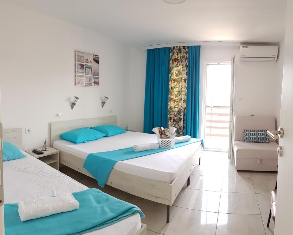 2 letti in una camera con blu e bianco di Apartments Villa Naumovi a Star Dojran