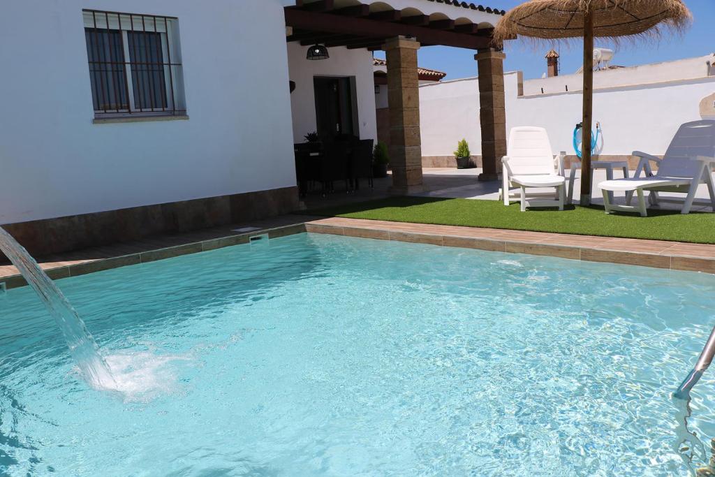a swimming pool with a water fountain at Chalet carril de los pareja in Conil de la Frontera