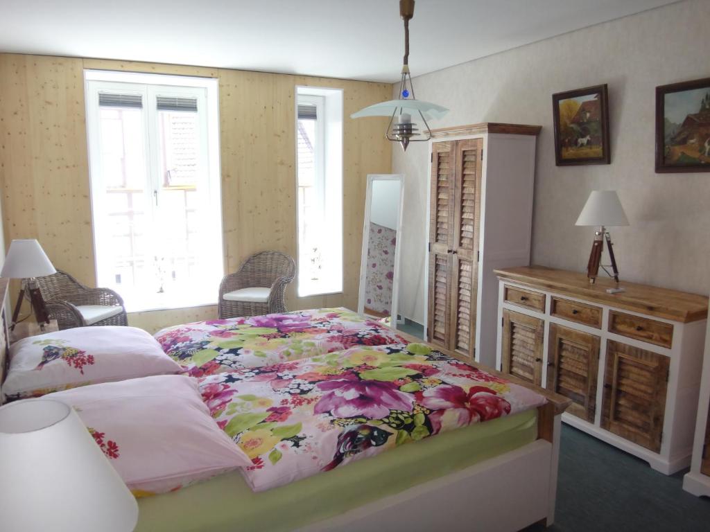 - une chambre avec un grand lit et une couverture fleurie dans l'établissement Amazing Elli, à Wernigerode