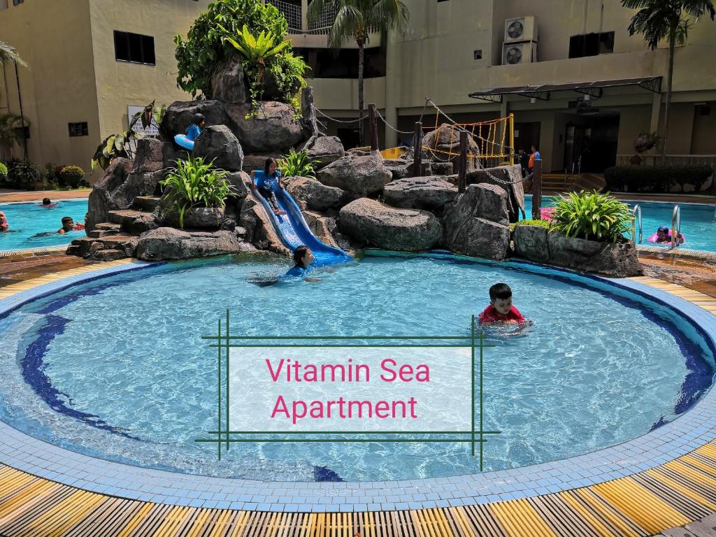 a swimming pool with a water slide in a resort at 2 mins to beach Apartment 3 rooms in Pasir Bogak