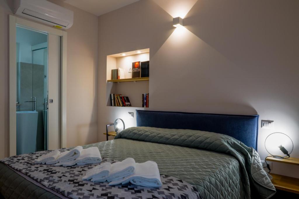 een slaapkamer met een bed met witte schoenen erop bij Bed&Book in Matera