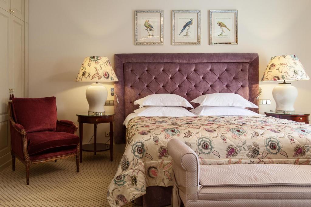 維爾紐斯的住宿－NARUTIS hotel，一间卧室配有一张大床和一把椅子
