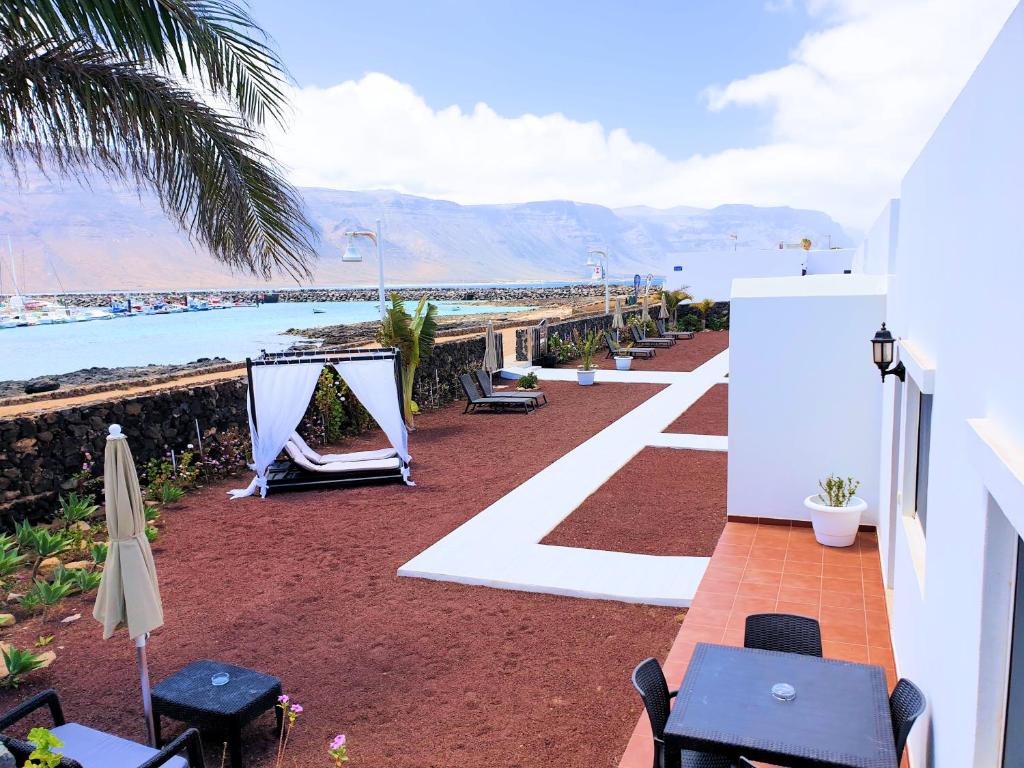 eine Terrasse mit Blick auf den Strand und das Meer in der Unterkunft La Graciosa Camelia Beach Vistas Mar in Caleta de Sebo