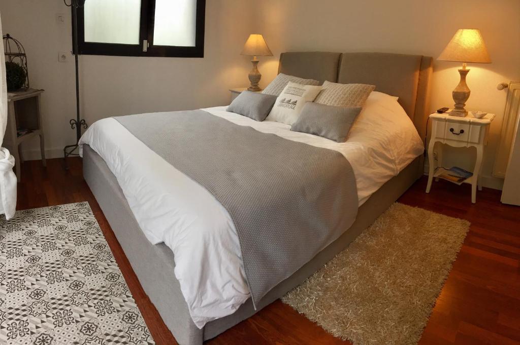 ein großes weißes Bett in einem Schlafzimmer mit zwei Lampen in der Unterkunft Chambre kercaves in Larmor-Plage