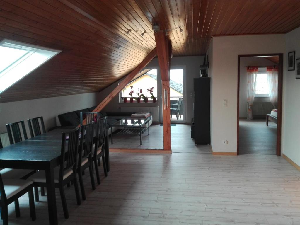 ein Esszimmer und ein Wohnzimmer mit Holzdecke in der Unterkunft Obere Ferienwohnung Asshoff zwischen Odenwald, Taubertal und Bauland in Berolzheim