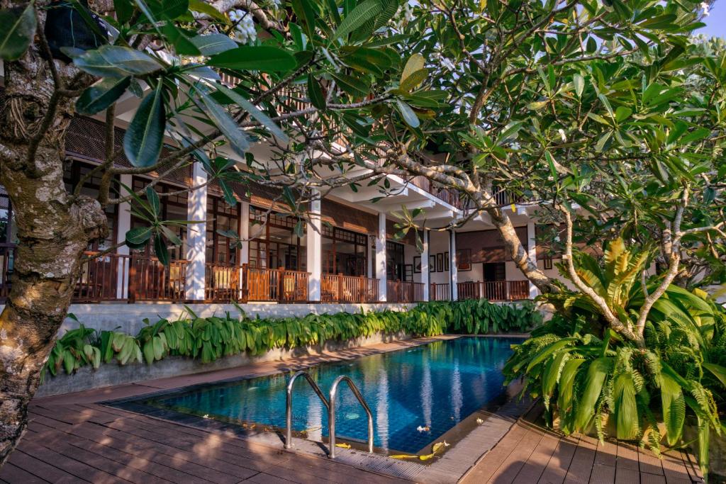 una piscina en medio de un edificio con árboles en The Postcard Galle en Galle