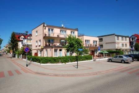 a street with cars parked in front of buildings at Dom na Fali Darlowko in Darlowko