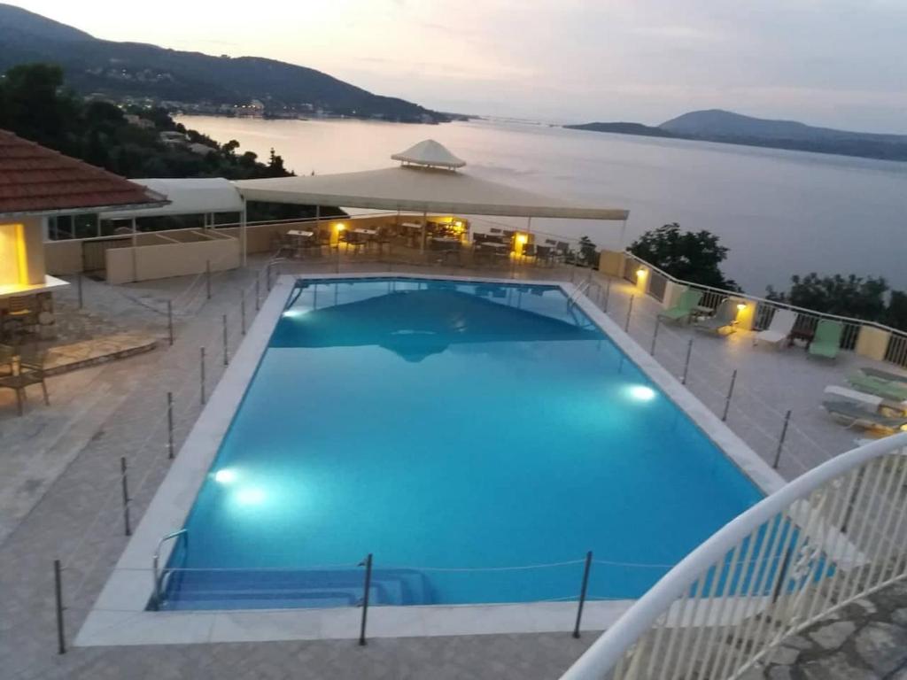 a large swimming pool with a view of the water at Sunrise Hotel Nikiana Lefkada in Nikiana