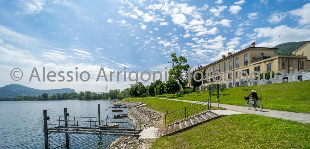 a person riding a bike on a path next to a lake at BlueLake Inn in Olginate