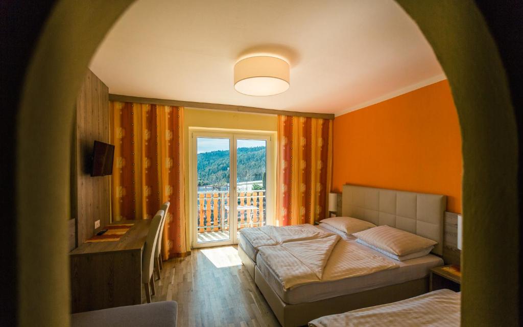 1 dormitorio con 2 camas y ventana en Sonnenhof Hechtl, en Mönichkirchen
