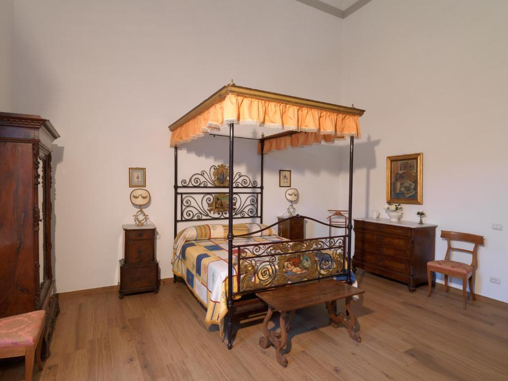 1 dormitorio con cama con dosel y suelo de madera en Giardino D'Azeglio Locazione Turistica, en Florencia