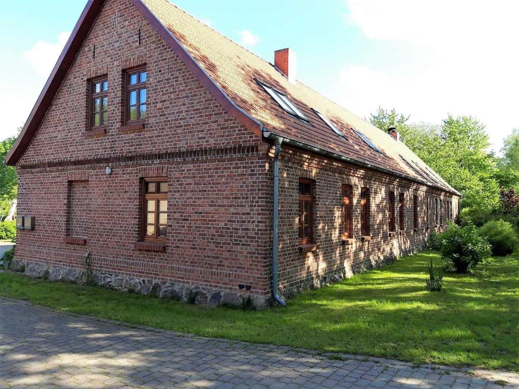 an old brick building with a rusty roof at Ruegen_Fewo 59 in Poseritz