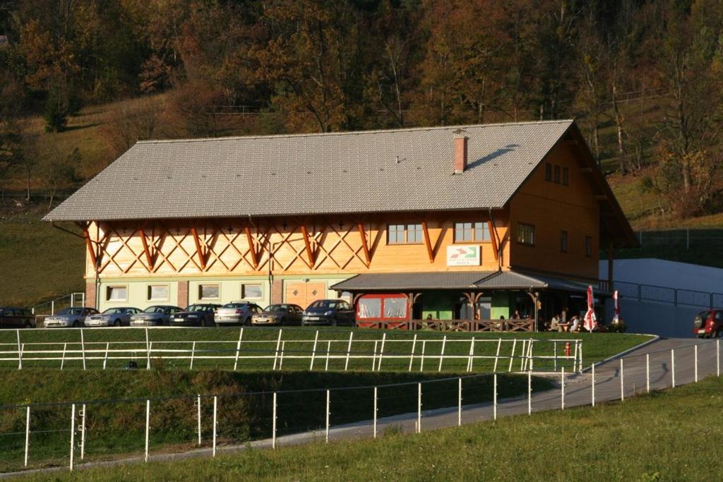 a large barn with cars parked in front of it at Apartmaji Bršca in Begunje na Gorenjskem
