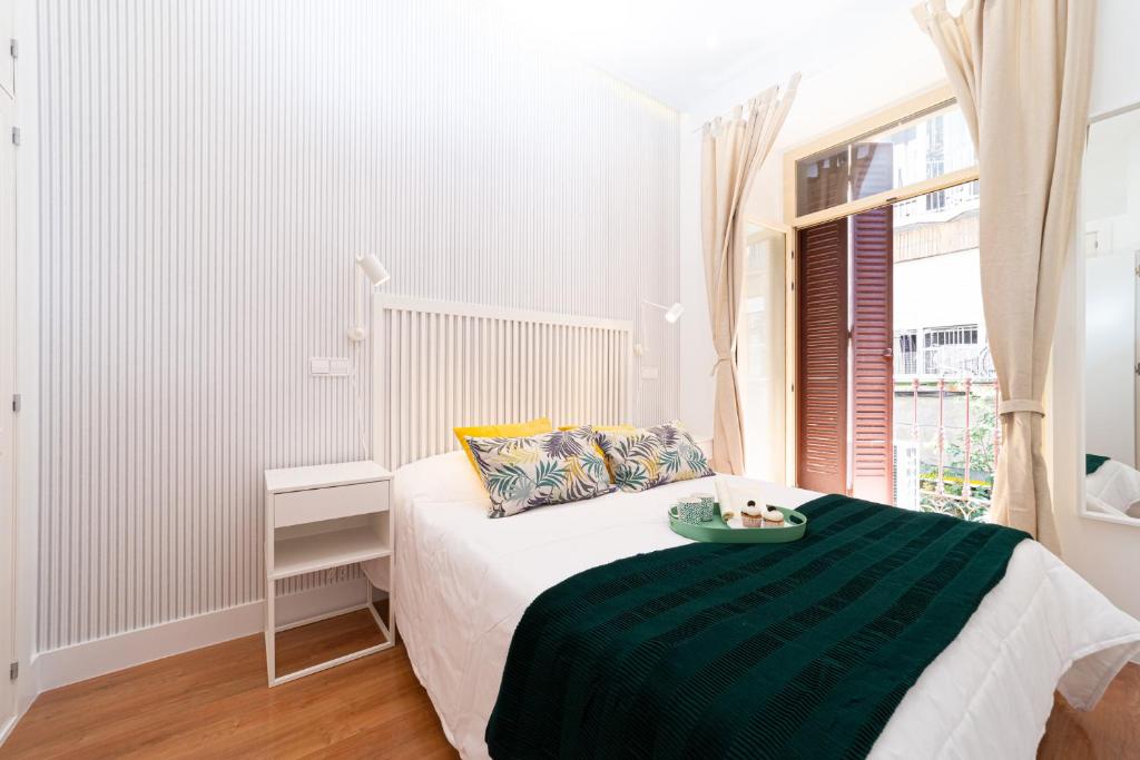 マドリードにあるFUENCARRALのベッドルーム1室(緑の毛布、窓付)