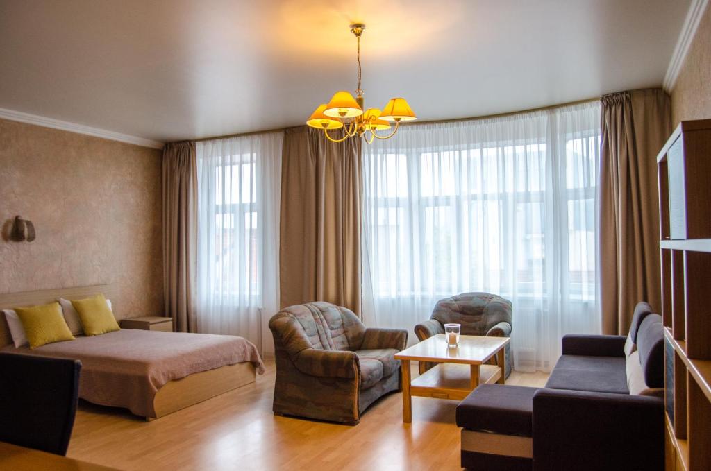 a hotel room with a bed and a living room at City Inn Riga Apartment, Old Town History Heritage with parking in Riga