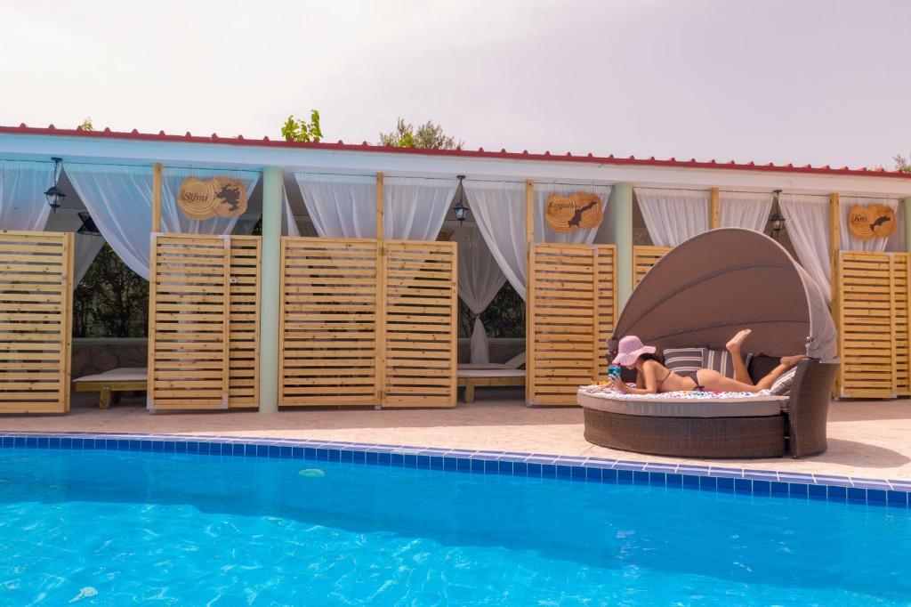 een paar mensen in een bed naast een zwembad bij Fantasy Hotel in Kolimbia