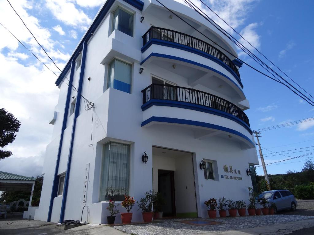 un edificio blanco con balcones azules en Green Beauty Homestay en Hengchun