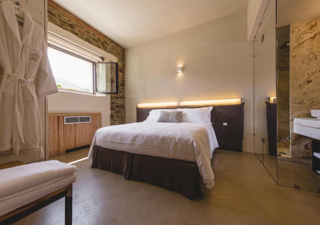 a bedroom with a bed and a window and a sink at Torre di Baratti Bio Resort in Populonia
