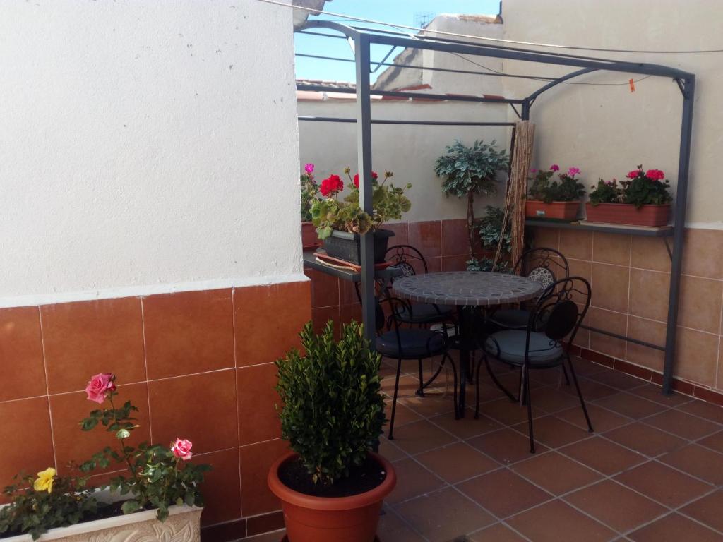 patio ze stołem, krzesłami i doniczkami w obiekcie CASA RURAL LA CASILLA DE MILA w mieście Frómista