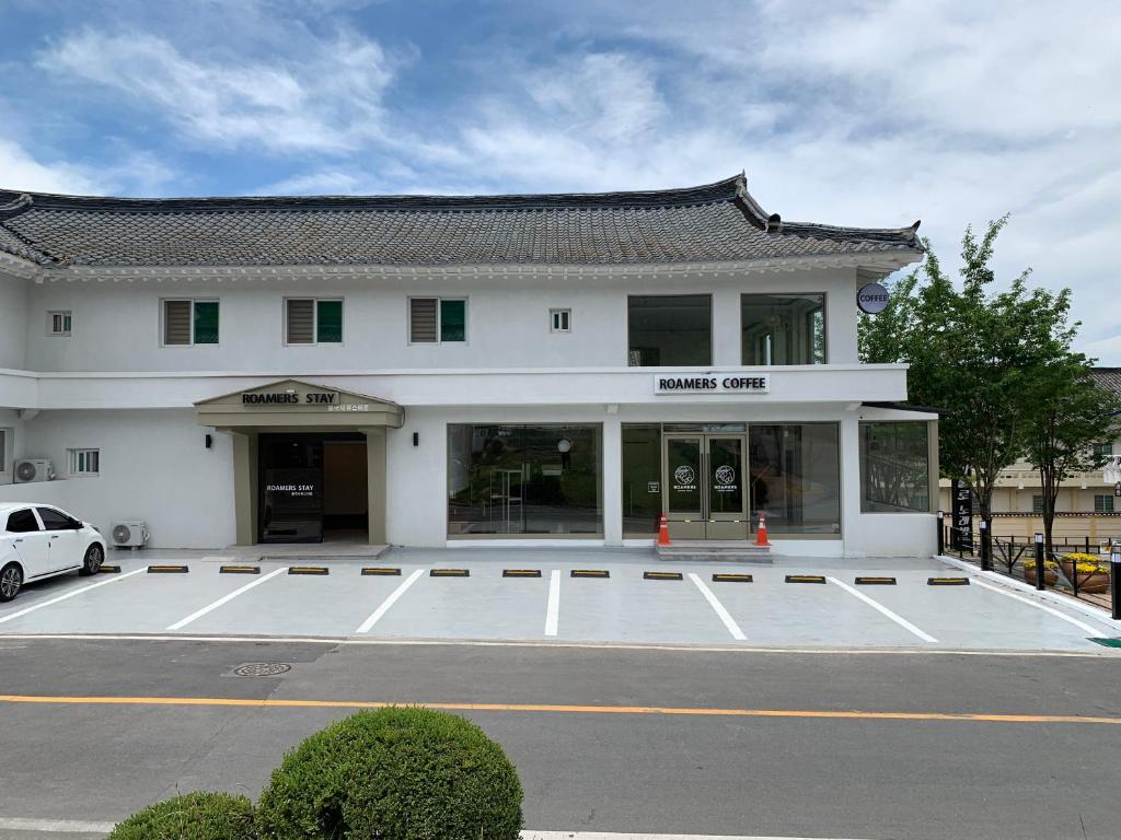 a building with a parking lot in front of it at Gyeongju Roamers Stay in Gyeongju