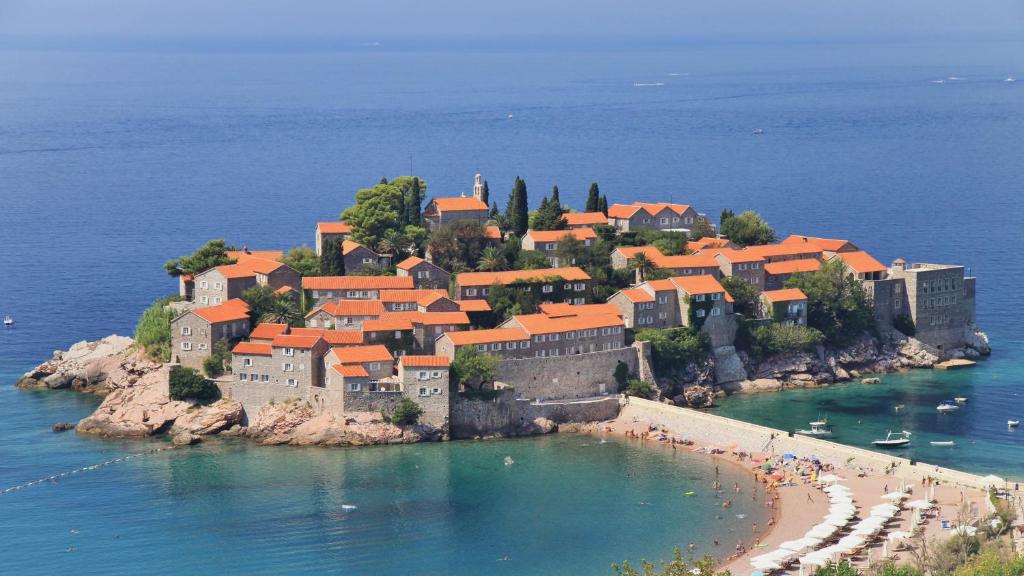 an island with a castle in the water at Hotel & Apartments HEC Residence in Sveti Stefan