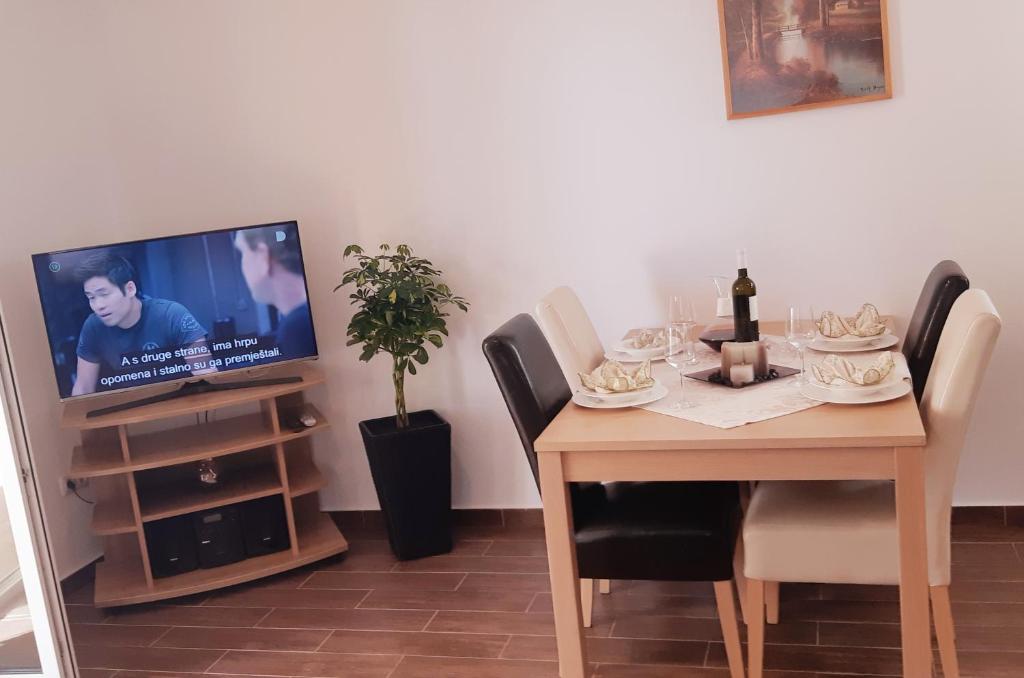 Televízia a/alebo spoločenská miestnosť v ubytovaní Apartmani Lili
