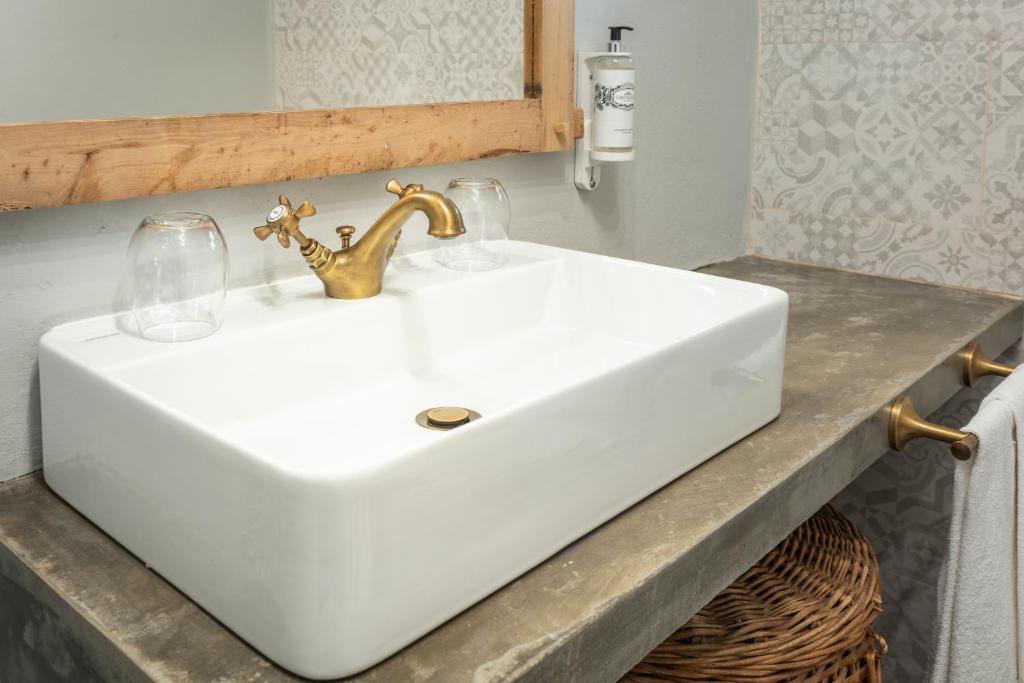 a white sink in a bathroom with a mirror at Aldeia da Cuada in Faja Grande