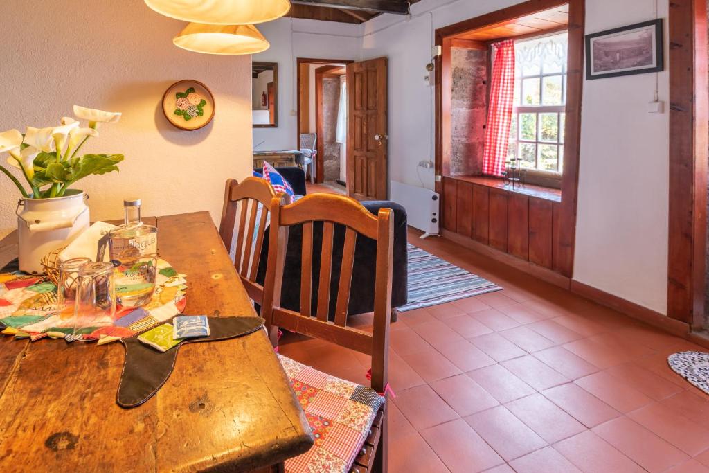 a wooden table and chairs in a room with a dining room at Aldeia da Cuada in Faja Grande