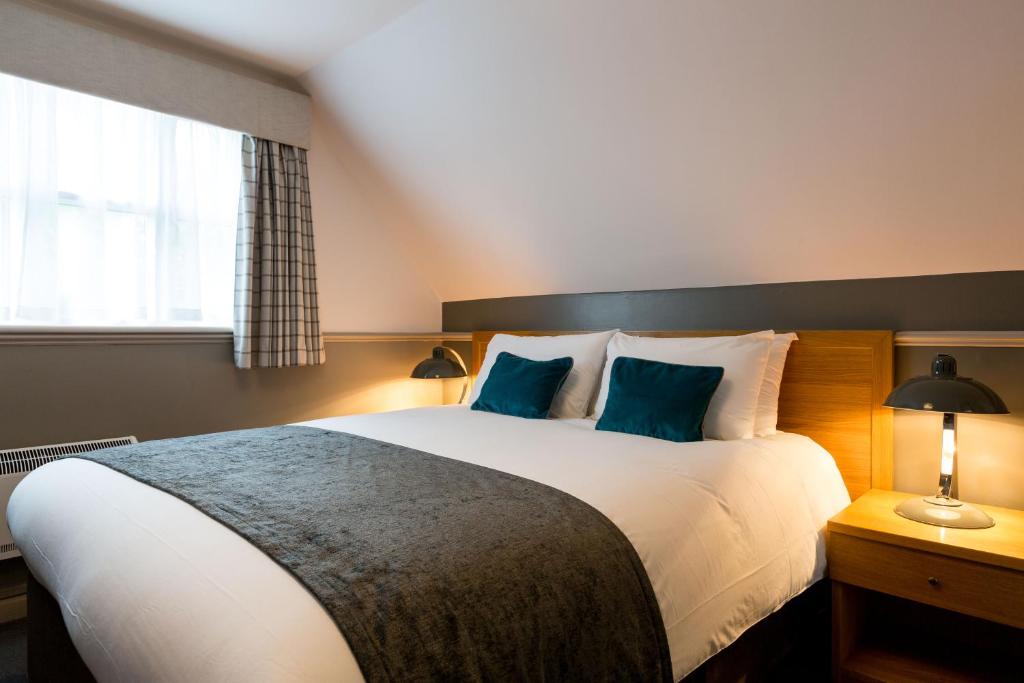 a hotel room with a large bed and a large window at White Hart by Chef & Brewer Collection in Chalfont Saint Giles