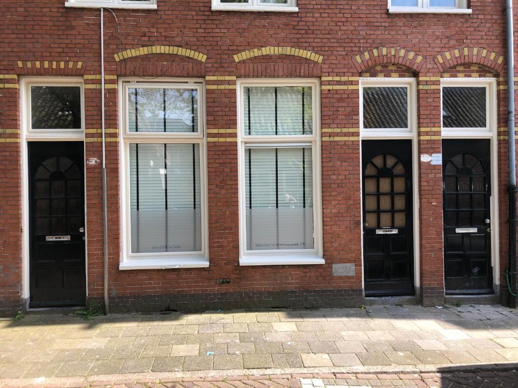 a brick building with four windows and doors at Westerbinnensingel in Groningen