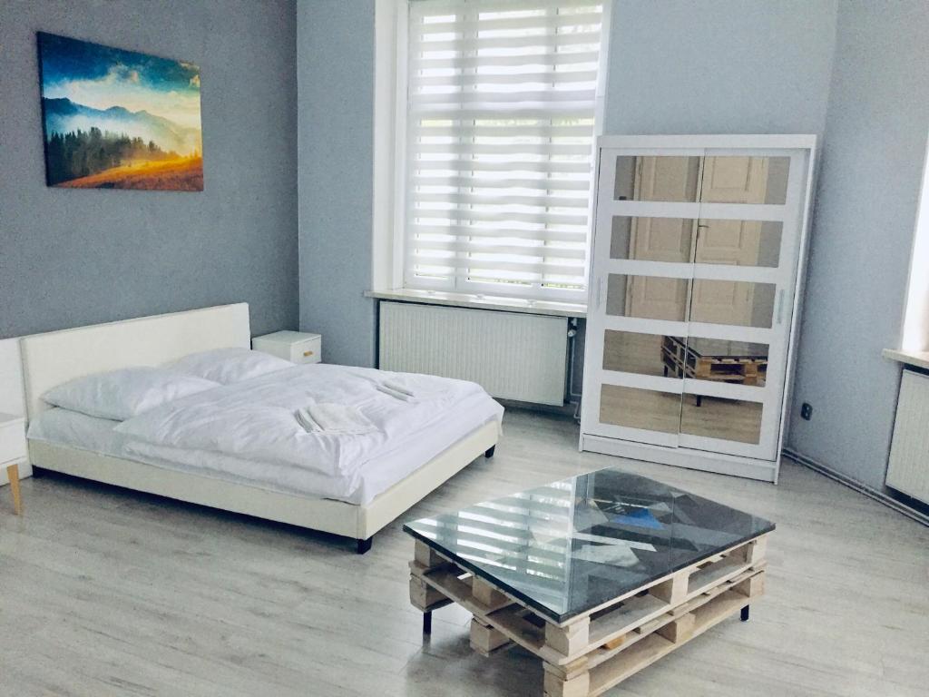 a bedroom with a bed and a glass coffee table at Rebel Apartament in Bielsko-Biała