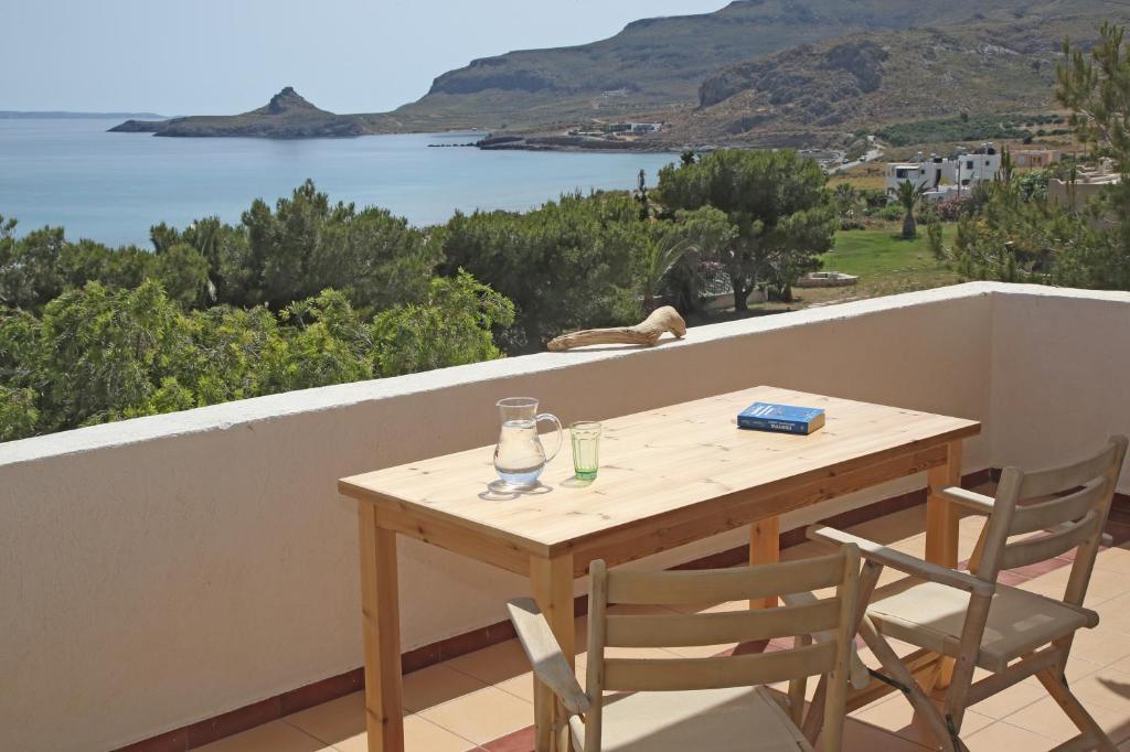 een tafel en stoelen op een balkon met uitzicht op het water bij Aqua Bliss in Xerokampos