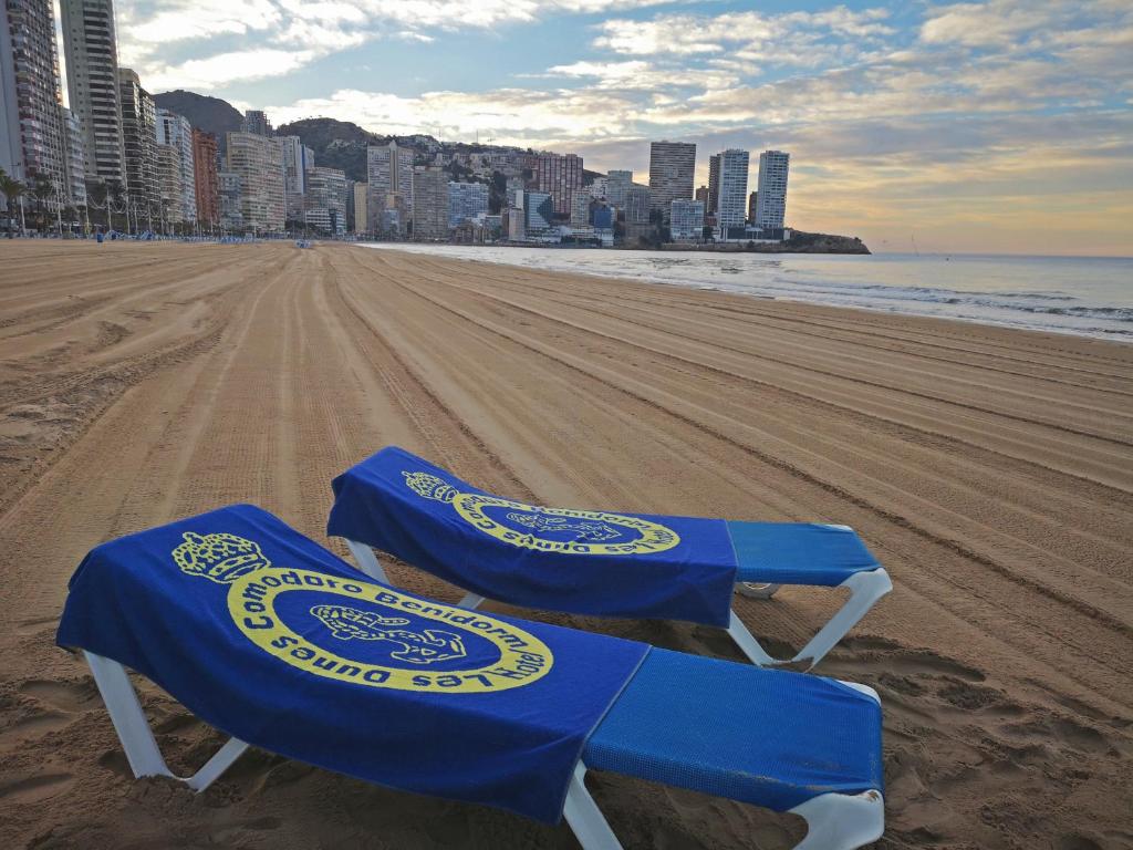 two beach chairs sitting on the sand at the beach at Les Dunes Comodoro in Benidorm