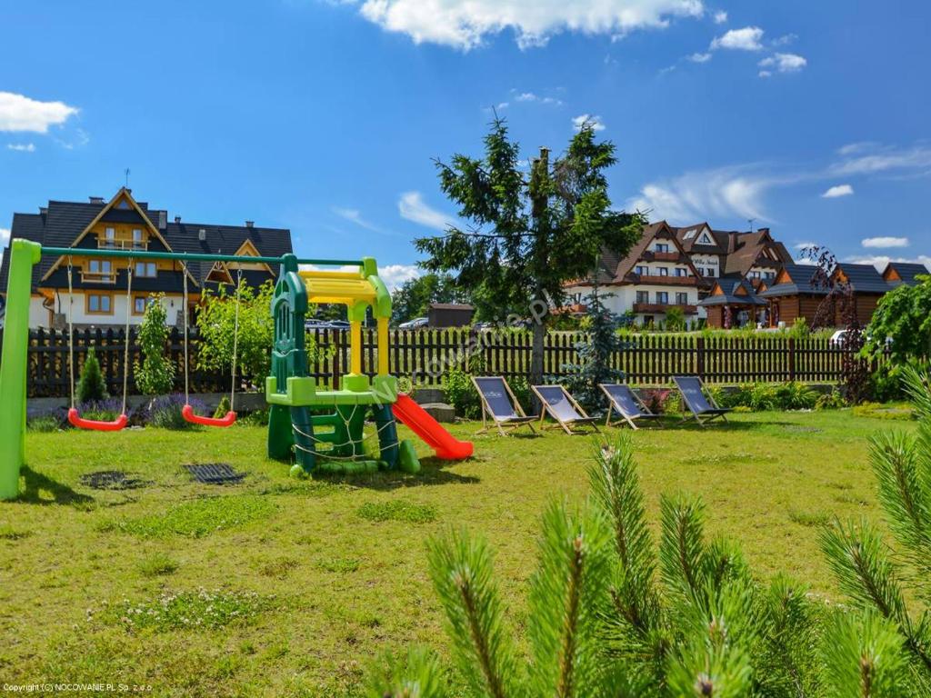 plac zabaw z krzesłami i zjeżdżalnią na dziedzińcu w obiekcie Willa Pod Termą - pokoje przy Termie Bania w mieście Białka Tatrzanska
